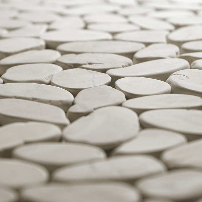 Les carreaux de pierre lisses et ovales s'emboîtent étroitement, créant une surface homogène dans un environnement doucement écl