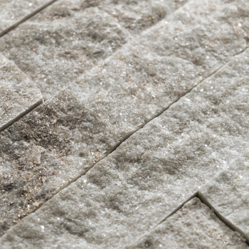 Ruwe, gestructureerde stenen tegels liggen horizontaal gestapeld en laten een natuurlijke, aardse mix van lichte en donkere tint