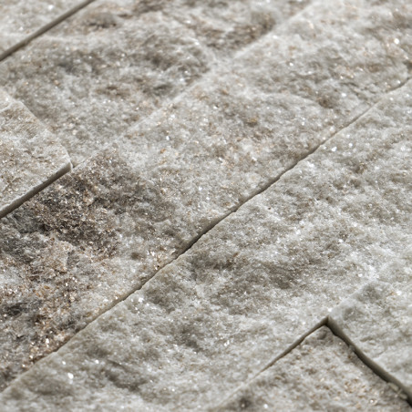 Ruwe, gestructureerde stenen tegels liggen horizontaal gestapeld en laten een natuurlijke, aardse mix van lichte en donkere tint