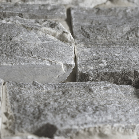 Naast elkaar geplaatste grijze steentegels vormen een gestructureerd oppervlak in een natuurlijke, ruige omgeving. Naast elkaar geplaatste grijze steentegels vormen een gestructureerd oppervlak in een natuurlijke, ruige omgeving.
