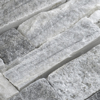 Rectangular stone tiles are fitted together, showcasing rough, varied textures and shades of gray, creating a rustic surface.