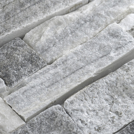 Rectangular stone tiles are fitted together, showcasing rough, varied textures and shades of gray, creating a rustic surface.