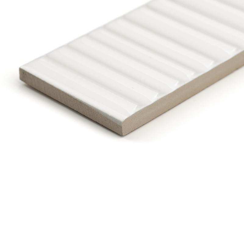 Un carreau de céramique rectangulaire présente une surface blanche brillante et nervurée. il repose sur un socle beige, isolé su