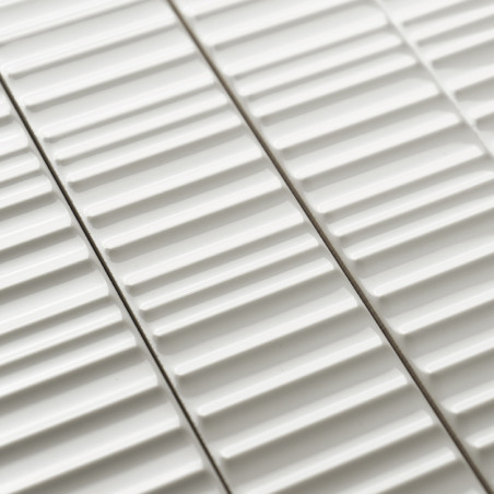 Weiße Keramikfliesen weisen erhabene lineare Rippen auf, die parallel angeordnet sind und ein strukturiertes Muster erzeugen. Si Weiße Keramikfliesen weisen erhabene lineare Rippen auf, die parallel angeordnet sind und ein strukturiertes Muster erzeugen. Si