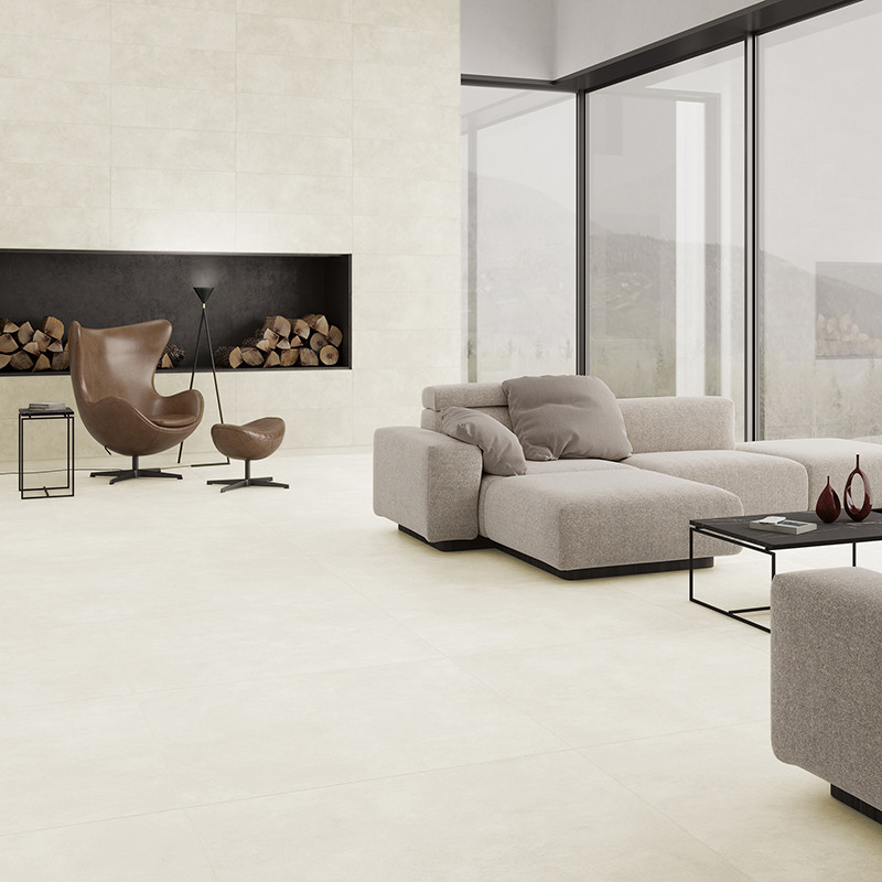 A modern living room features a large beige sectional sofa facing a sleek, black fireplace, with logs stacked inside, and large 