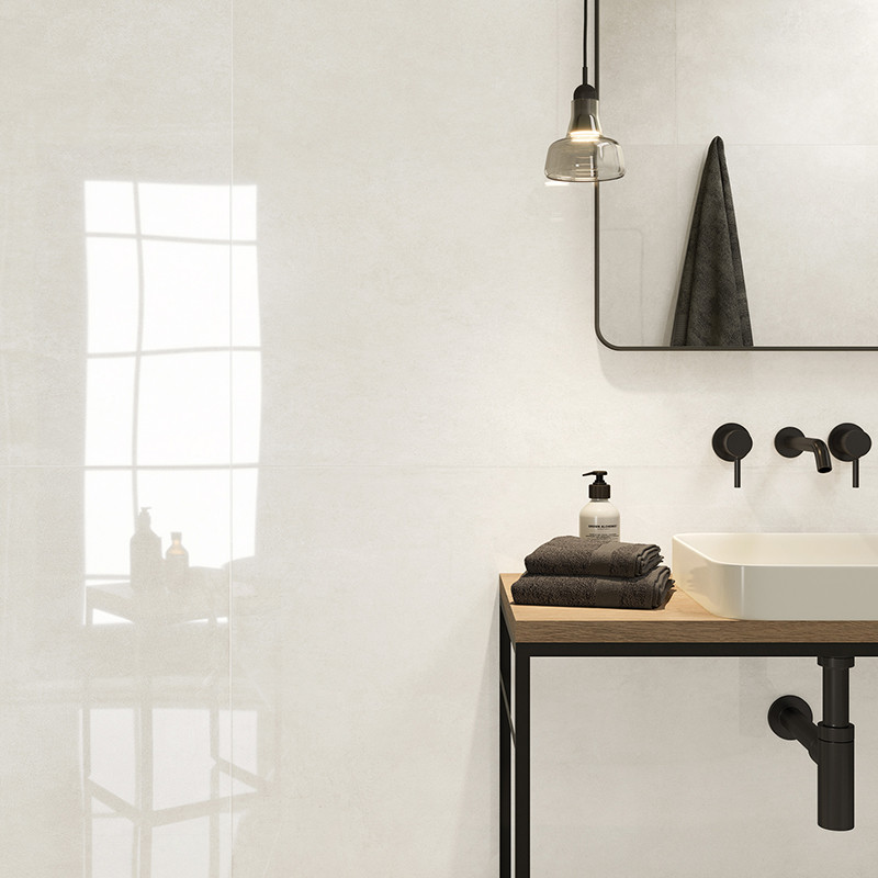 Een witte badkamer is voorzien van een minimalistische wastafel op een houten aanrecht, met zwarte armaturen, een hanglamp en ee