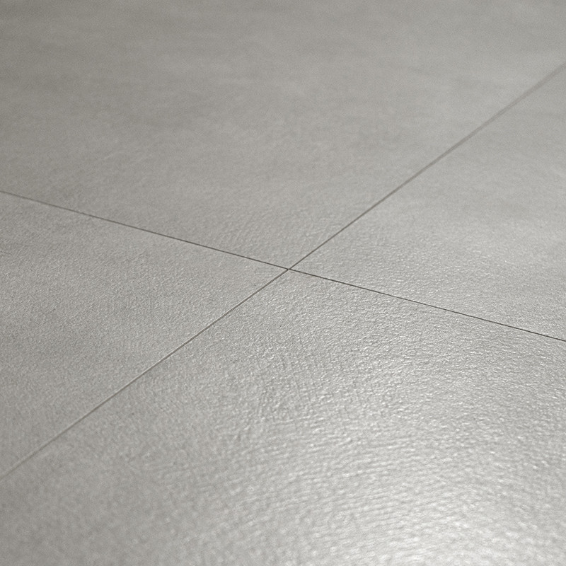 Les carreaux de sol gris forment un motif lisse et homogène, se croisant à angle droit, dans une pièce minimaliste.