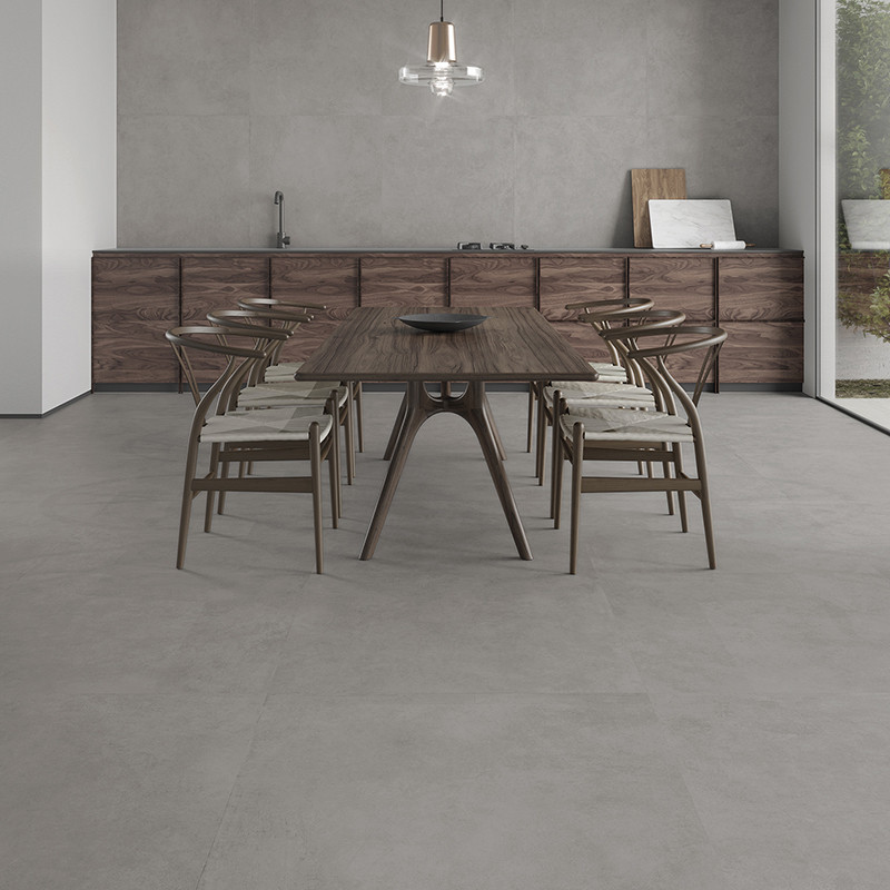 Uma mesa de jantar de madeira com cadeiras fica sobre um piso liso de cerâmica cinza claro em uma cozinha moderna com decoração 