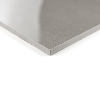 Eine glatte, glänzende graue Fliese liegt schräg und zeigt eine glatte, reflektierende Oberfläche. Es liegt auf einem schlichten