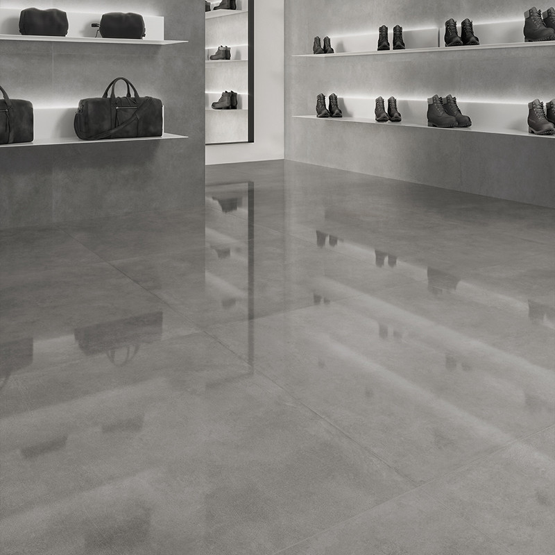 El piso de azulejos grises brilla, reflejando un entorno minorista con estantes que exhiben bolsos y botas de cuero oscuro contr