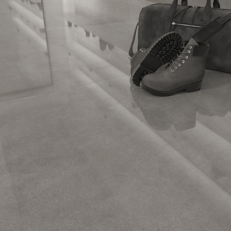 Ein Paar schwarze Stiefel ruht neben einer passenden Reisetasche auf einem glänzenden, reflektierenden Fliesenboden, der an eine