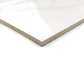 Een witte keramische tegel met een glanzende afwerking en afgeschuinde rand ligt op een witte achtergrond en reflecteert natuurl