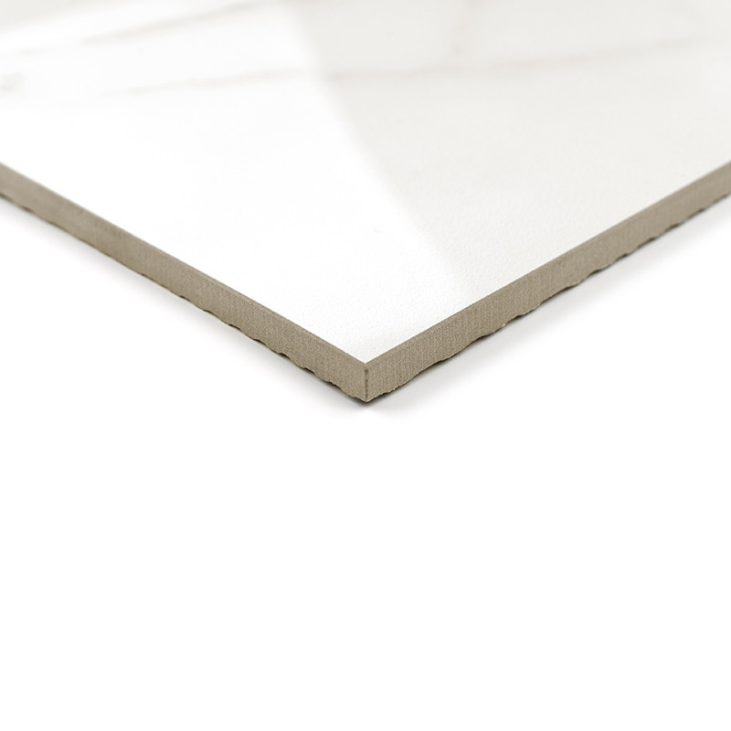 A white ceramic tile with a glossy finish and beveled edge lies on a white background, reflecting natural light from above.