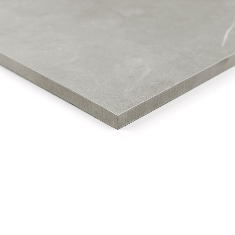 Un carreau de céramique lisse et gris repose sur une surface blanche, mettant en valeur son bord net et angulaire, suggérant un 