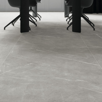 Gray marble tiles cover a sleek, modern floor beneath dark chairs and a long table, creating an elegant conference room setting.
