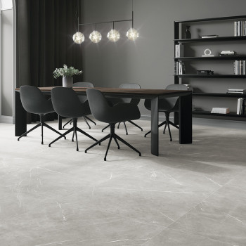 A modern dining area features a wooden table with six black chairs, under spherical pendant lights, against a backdrop of booksh