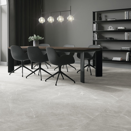 A modern dining area features a wooden table with six black chairs, under spherical pendant lights, against a backdrop of booksh