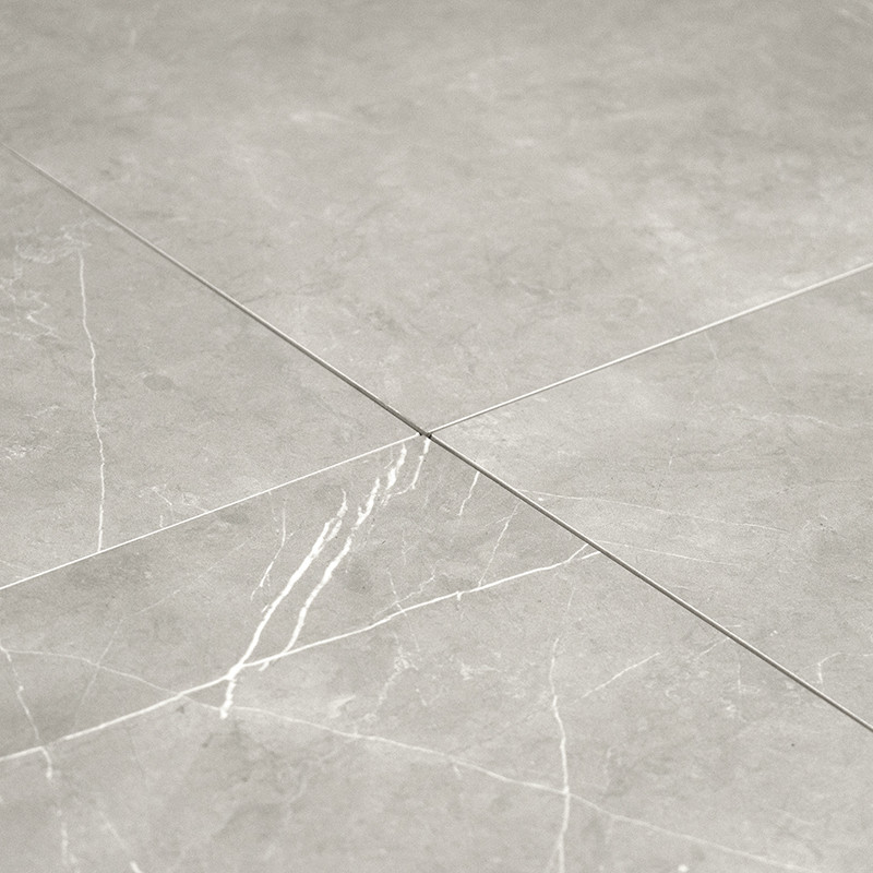 Les carreaux de céramique grise se croisent, mettant en valeur de subtiles veines blanches. Ils sont soigneusement disposés sur 