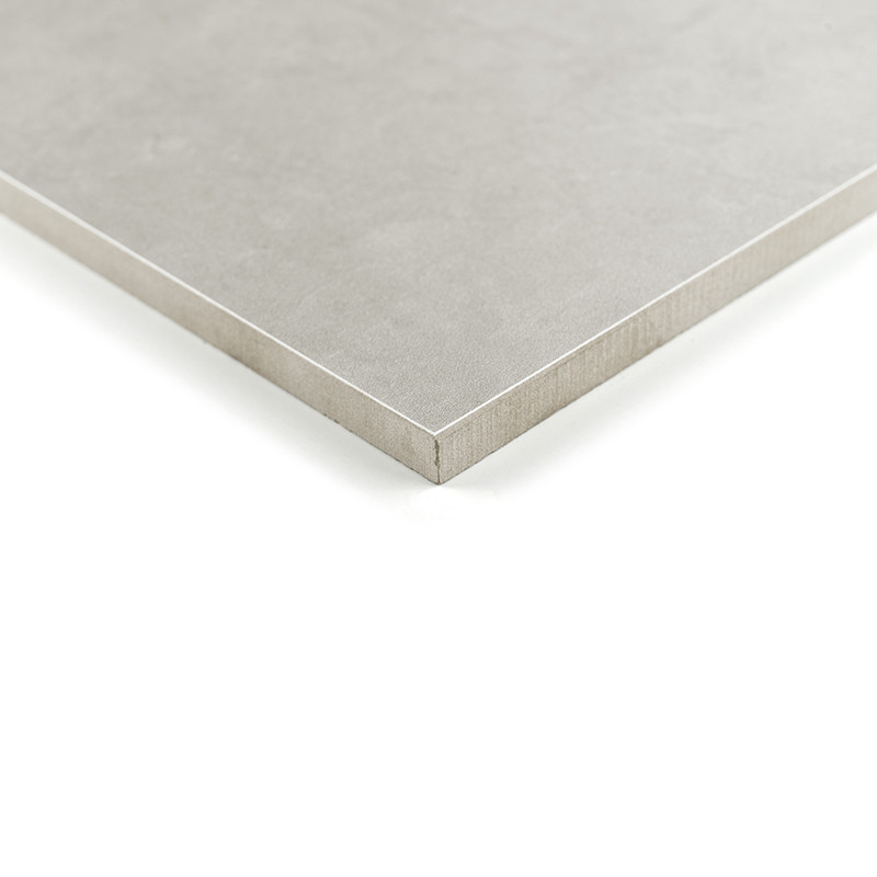 Un carreau carré gris mat repose sur une surface blanche, ses bords nets définissant un design épuré et minimaliste.