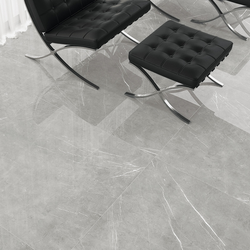 Sillas de cuero negro con capitoné descansan sobre azulejos con motivos de mármol de color gris claro. la habitación parece mode