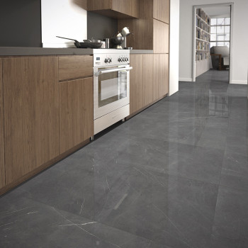 Glänzende graue Fliesen bedecken den Boden und reflektieren das Licht in einer modernen Küche mit Holzschränken und Geräten aus 