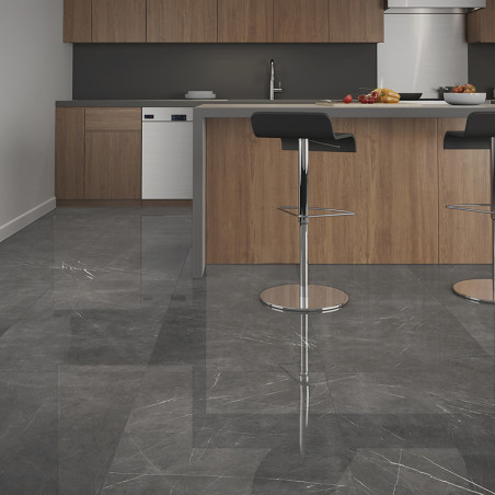 Graue Marmorfliesen bedecken einen modernen Küchenboden und reflektieren das Licht. Holzschränke und eine Mittelinsel mit Barhoc