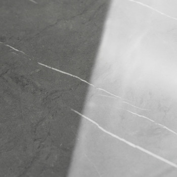 Die Fliese hat eine glatte, diagonal geteilte Oberfläche. Eine Seite ist dunkelgrau, die andere hellgrau, beide mit dezenten wei