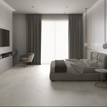 Um quarto moderno dispõe de uma cama baixa estofada posicionada perto de cortinas do chão ao teto. Uma cadeira minimalista e mes