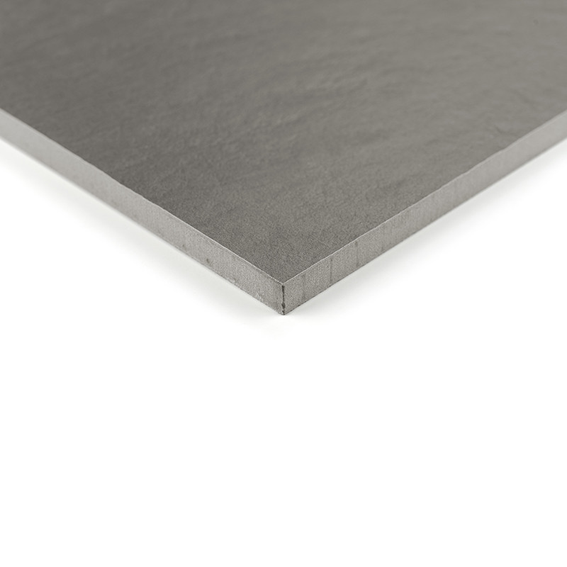 A gray, square ceramic tile with a smooth, matte finish is shown resting on a neutral, white background.