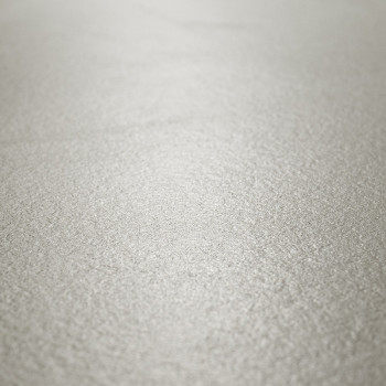 Eine strukturierte, hellgraue Fliesenoberfläche wirkt glatt und dennoch dezent körnig und reflektiert sanftes Licht in einer neu