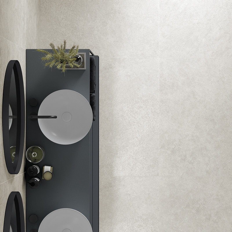 A sleek, rectangular bathroom counter holds two circular sinks with modern faucets. Above, mirrors are placed. the wall features