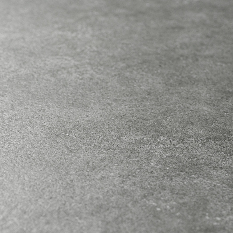 Eine glatte, graue Fliese mit dezenter Textur liegt auf einer ebenen Fläche und sorgt für ein ruhiges, minimalistisches Erschein