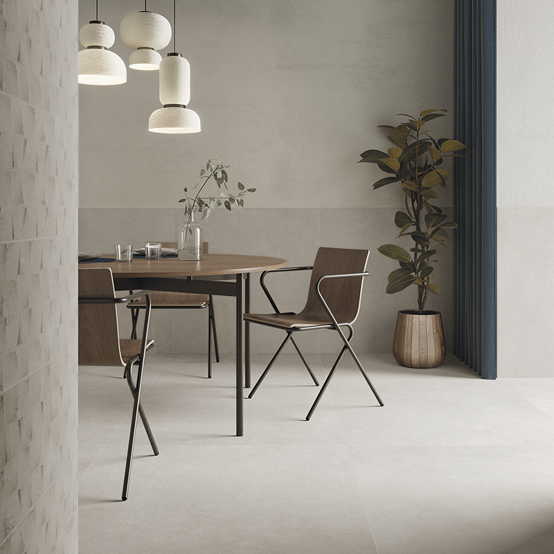 Ein hölzerner Esstisch mit Glaswaren und Pflanzen steht unter Pendelleuchten, umgeben von modernen Stühlen in einem minimalistis