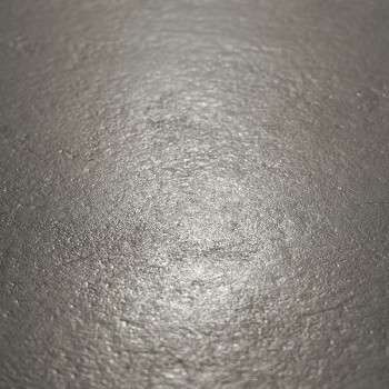 Die metallische Fliesenoberfläche reflektiert das Licht sanft und zeigt in einer neutralen, schwach beleuchteten Umgebung eine l