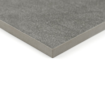 Un carreau de céramique carré gris à la surface lisse repose sur un fond blanc, soulignant son épaisseur et ses bords nets.