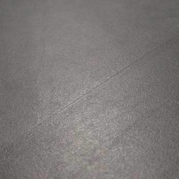 Une surface de carrelage lisse et gris mat est plate, montrant une subtile ligne de couture en diagonale, dans un contexte minim