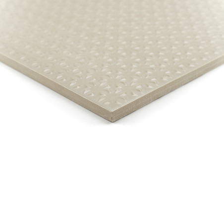 Eine quadratische beige Fliese liegt auf einem weißen Hintergrund und weist auf ihrer glatten Oberfläche ein erhabenes geometris