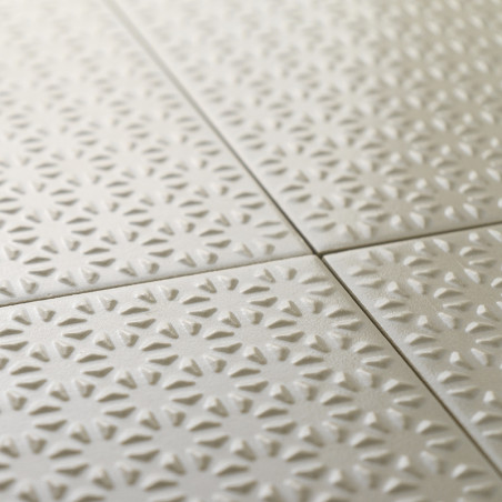 Strukturierte Keramikfliesen bilden ein sich wiederholendes Muster aus Sonnenstrahlen in sanftem Beige, die sauber in einem mit 