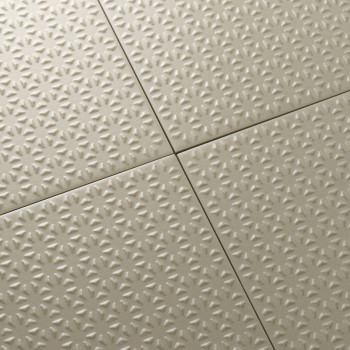 Die beigen Fliesen weisen ein durchgehendes, sternförmiges Prägemuster auf, das sauber in einer Gitterformation angeordnet ist u