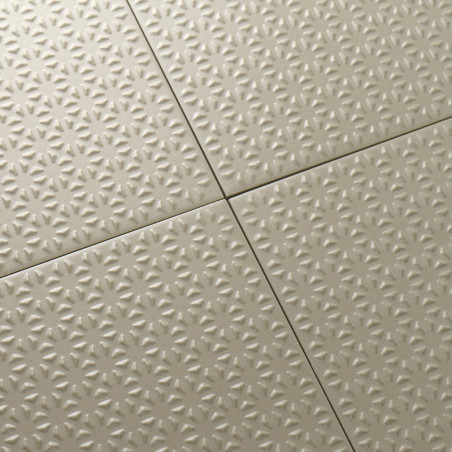 Die beigen Fliesen weisen ein durchgehendes, sternförmiges Prägemuster auf, das sauber in einer Gitterformation angeordnet ist u