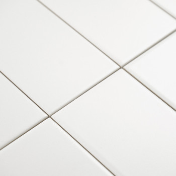 Ladrilhos retangulares brancos são alinhados em um padrão de grade, formando uma superfície perfeita e limpa em um ambiente mini