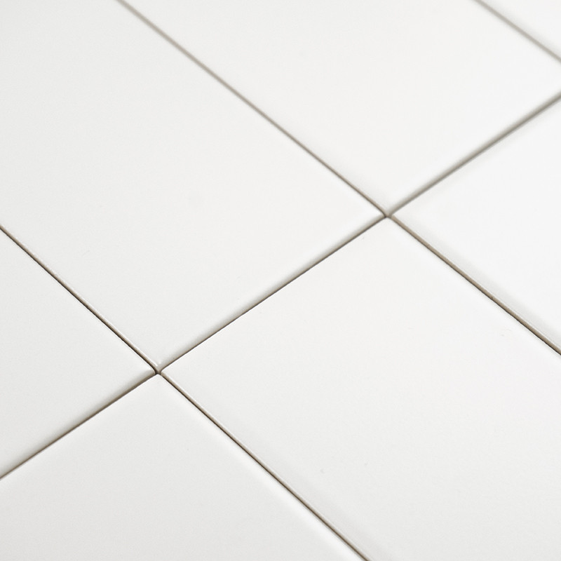 Ladrilhos retangulares brancos são alinhados em um padrão de grade, formando uma superfície perfeita e limpa em um ambiente mini