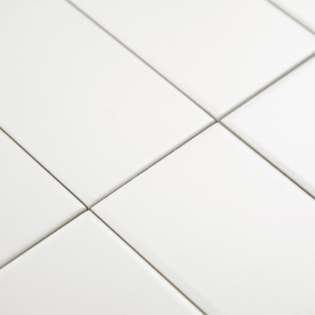 Ladrilhos retangulares brancos são alinhados em um padrão de grade, formando uma superfície perfeita e limpa em um ambiente mini