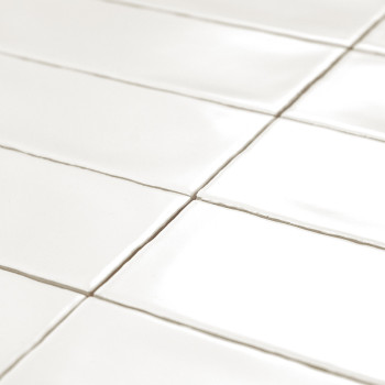 Glossy white rectangular tiles are neatly arranged in a grid pattern, reflecting light. context suggests a clean, modern surface