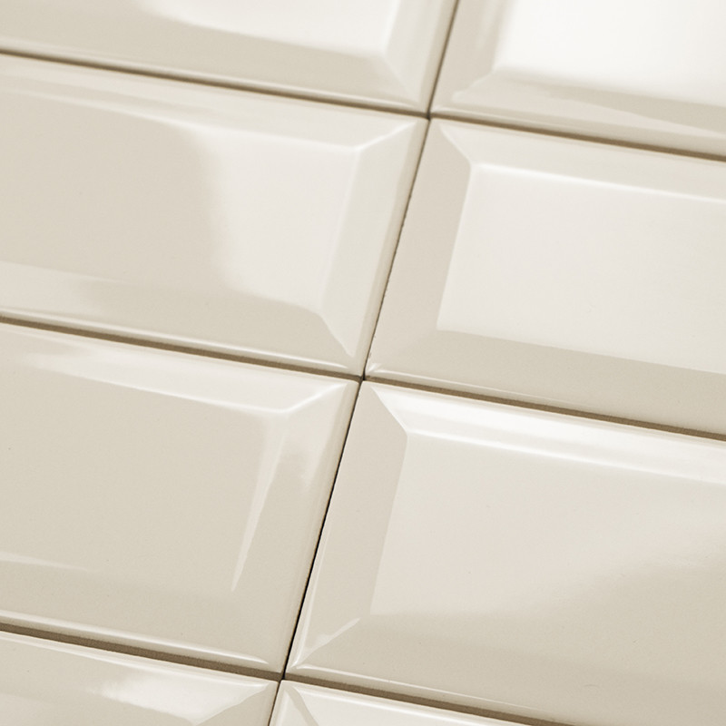 Carreaux de céramique disposés selon un motif en grille, réfléchissant la lumière, créant une surface brillante dans un décor in