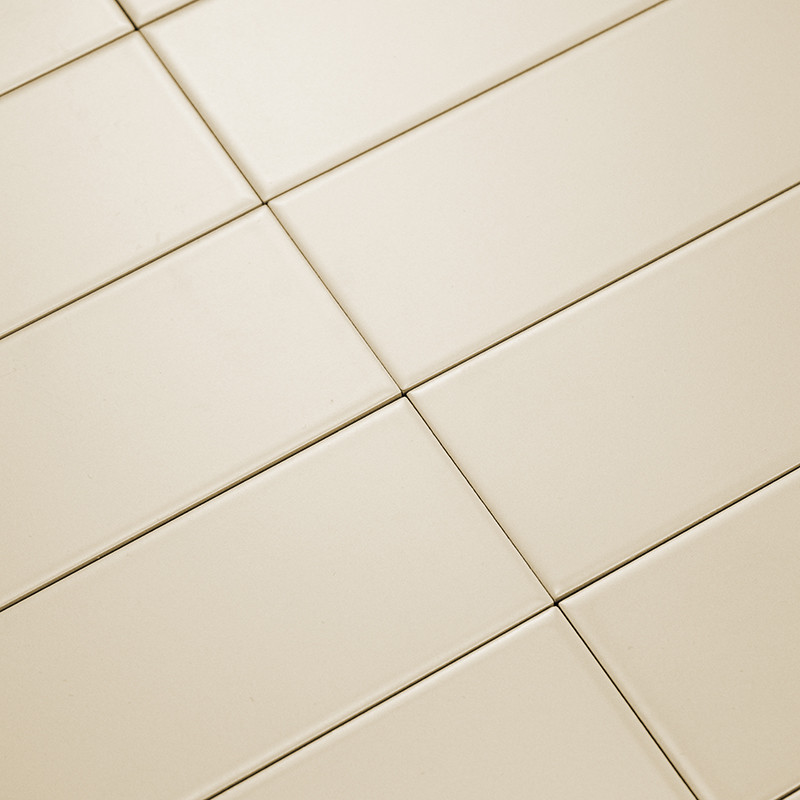 Los azulejos rectangulares de color crema estaban colocados en diagonal, formando un patrón de cuadrícula. La superficie lisa re
