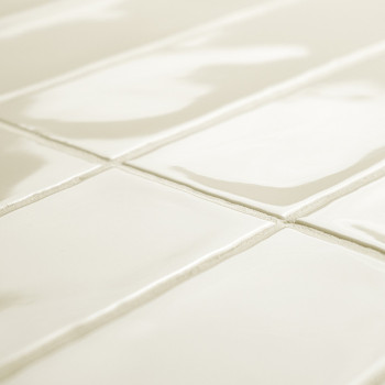 Glänzend weiße rechteckige Fliesen bilden ein Gittermuster, das das Licht in einem geräumigen Raum reflektiert, mit leicht sicht