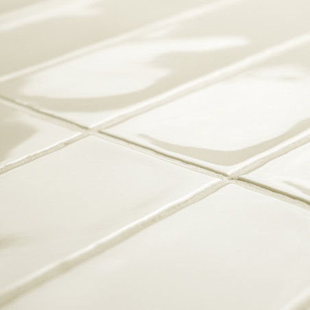 Glänzend weiße rechteckige Fliesen bilden ein Gittermuster, das das Licht in einem geräumigen Raum reflektiert, mit leicht sicht