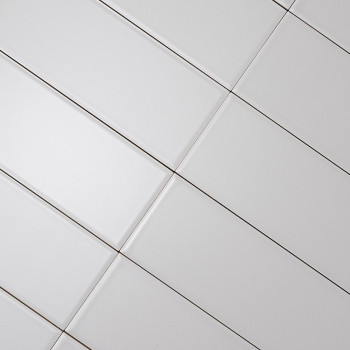 Weiße rechteckige Fliesen, die diagonal ausgerichtet sind und ein Gittermuster bilden. Dunkle Fugenlinien trennen die Fliesen un