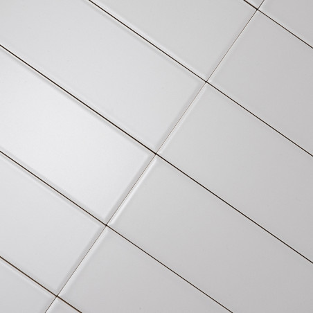 Weiße rechteckige Fliesen, die diagonal ausgerichtet sind und ein Gittermuster bilden. Dunkle Fugenlinien trennen die Fliesen un